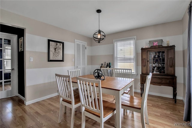 dining space with baseboards and light wood finished floors