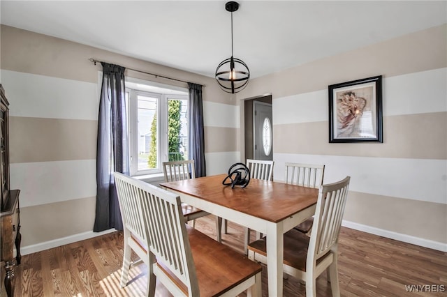 dining area with a notable chandelier, baseboards, and wood finished floors
