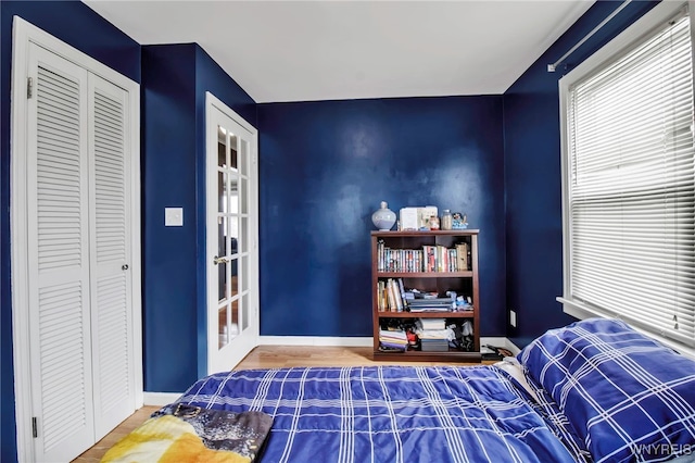 bedroom featuring a closet, baseboards, and wood finished floors