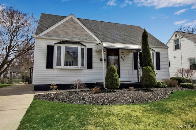 bungalow-style house with a shingled roof, stone siding, and a front lawn