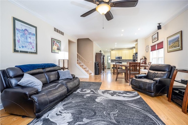 5572 Lakewood Trl, South Bristol, NY 14424 - living area with stairway, a ceiling fan, crown molding, light wood-style floors, and visible vents