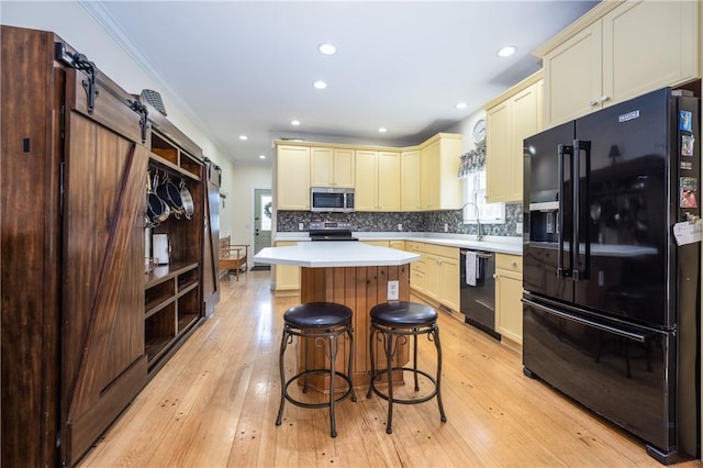 5572 Lakewood Trl, South Bristol, NY 14424 - kitchen with light countertops, a center island, black appliances, and cream cabinetry