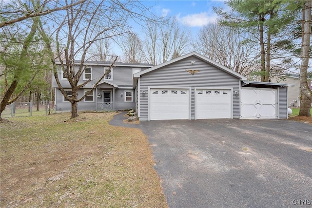 view of front of house with an attached garage, fence, and driveway