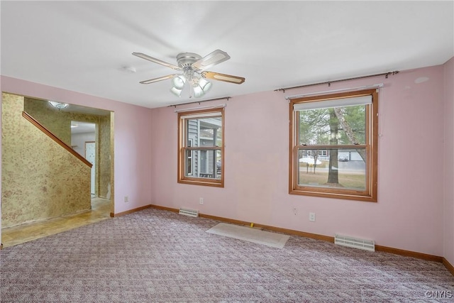 unfurnished room featuring carpet flooring, visible vents, and baseboards