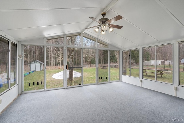 unfurnished sunroom featuring a ceiling fan, beam ceiling, and a healthy amount of sunlight