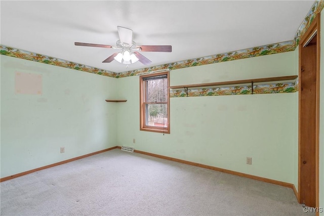 spare room with baseboards, ceiling fan, and carpet
