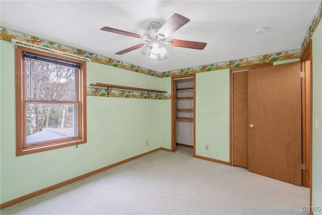 unfurnished bedroom with light colored carpet, baseboards, and ceiling fan