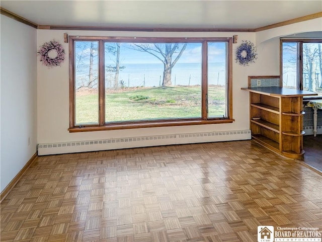 interior space with a wealth of natural light, a baseboard heating unit, and baseboards