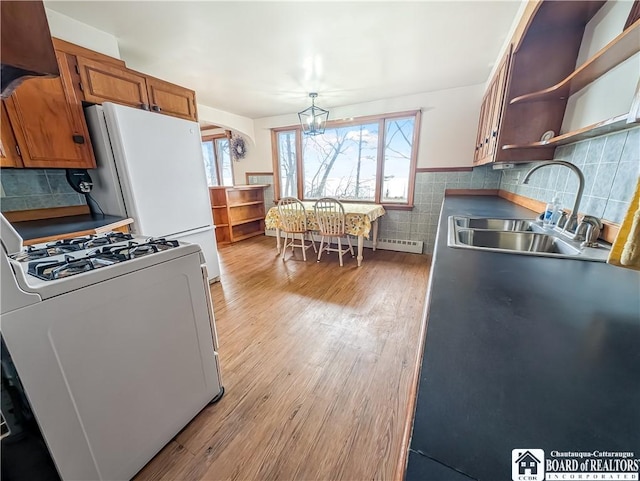 kitchen featuring brown cabinetry, gas stove, a sink, and plenty of natural light