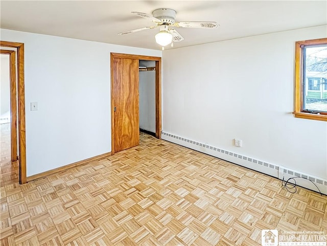 spare room with a baseboard heating unit, ceiling fan, and baseboards