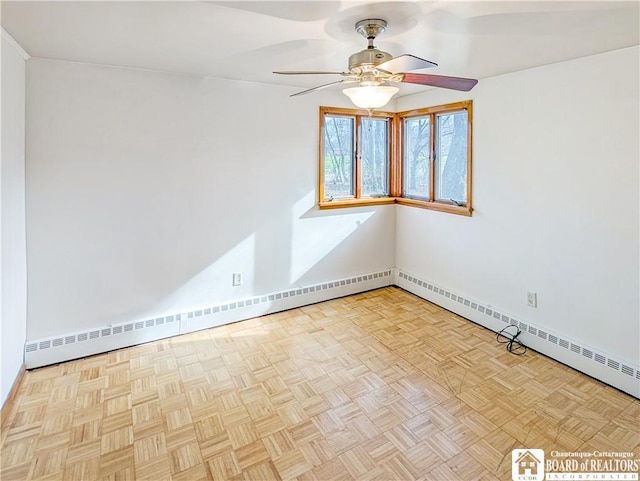 spare room featuring baseboard heating, baseboards, and a ceiling fan