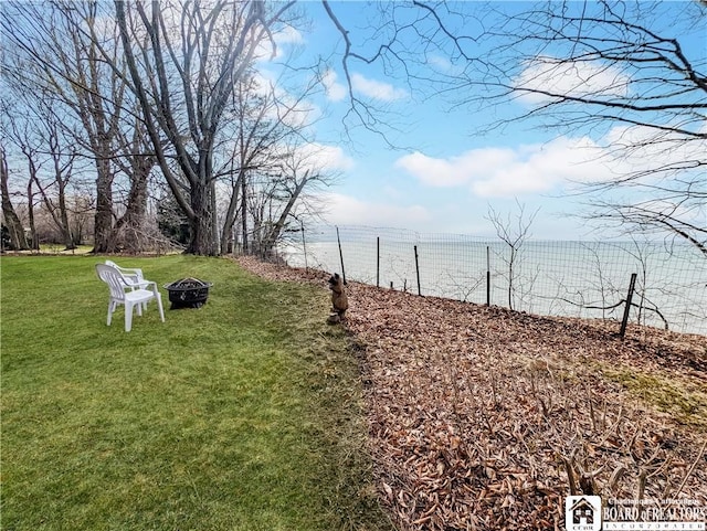 view of yard with a fire pit and a water view