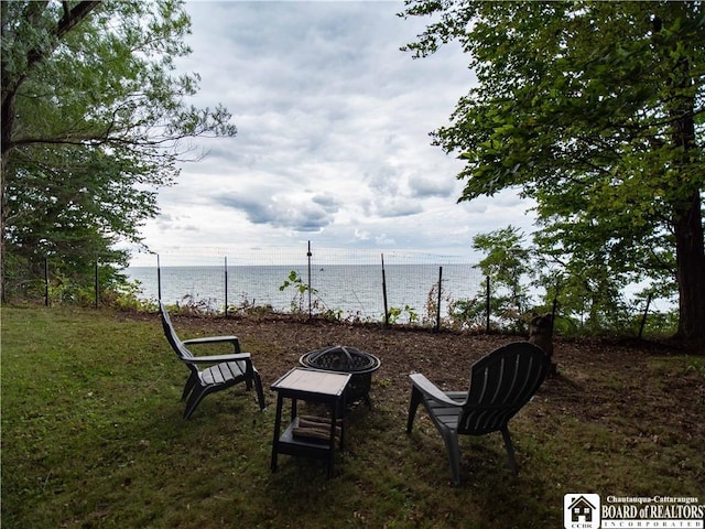 view of yard with a fire pit and a water view