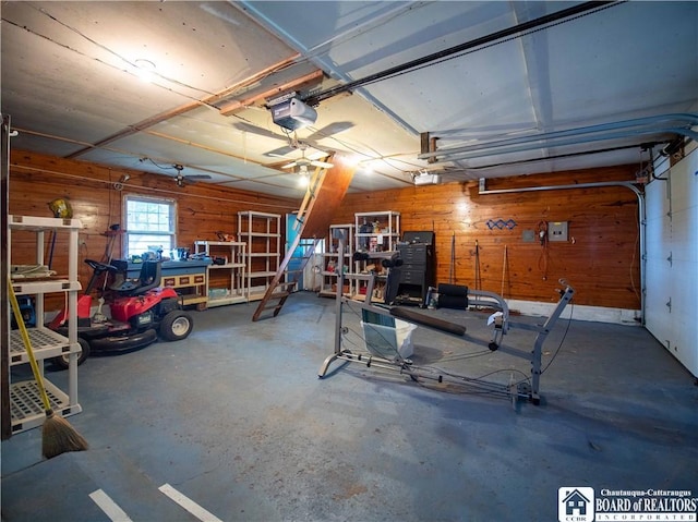 garage featuring a garage door opener, wooden walls, and a workshop area