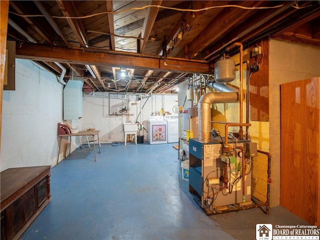 unfinished basement featuring gas water heater, electric panel, a sink, a heating unit, and washer and clothes dryer