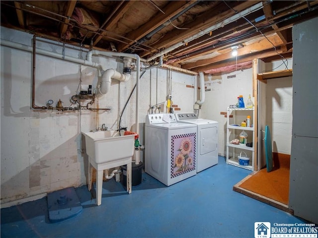 laundry area with laundry area, separate washer and dryer, and a sink