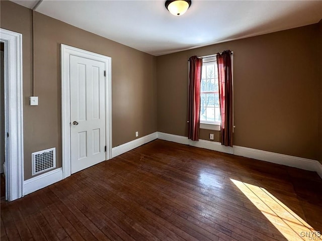 unfurnished bedroom with visible vents, baseboards, and hardwood / wood-style floors