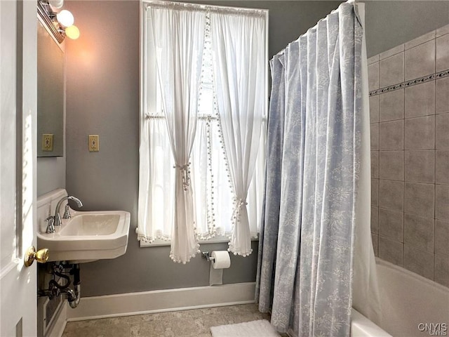 full bathroom with a sink, baseboards, and shower / bath combination with curtain