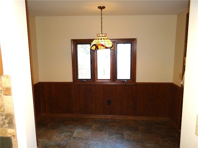 956 Hoffman St, Elmira-City, NY 14905 - unfurnished dining area with stone finish floor, wooden walls, and wainscoting