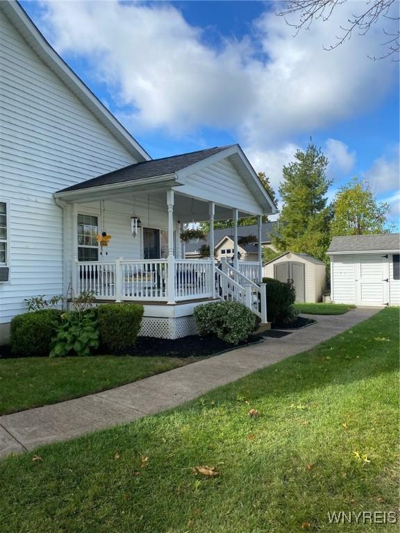 253 Glenvale Rd, Porter, NY 14174 - view of front of house featuring a storage shed, a front lawn, covered porch, and an outdoor structure