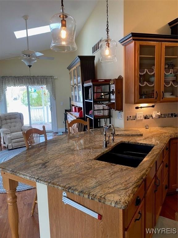 253 Glenvale Rd, Porter, NY 14174 - kitchen with brown cabinets, light stone counters, and a sink
