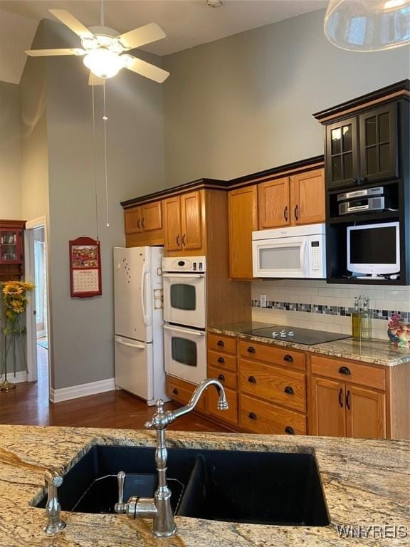 253 Glenvale Rd, Porter, NY 14174 - kitchen featuring high vaulted ceiling, white appliances, light stone countertops, a sink, and decorative backsplash