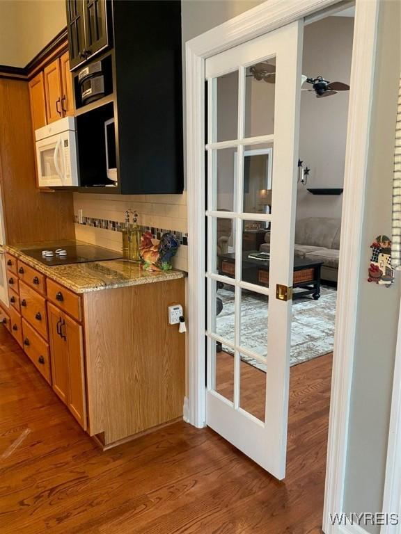 253 Glenvale Rd, Porter, NY 14174 - kitchen featuring light stone countertops, white microwave, black electric stovetop, and wood finished floors
