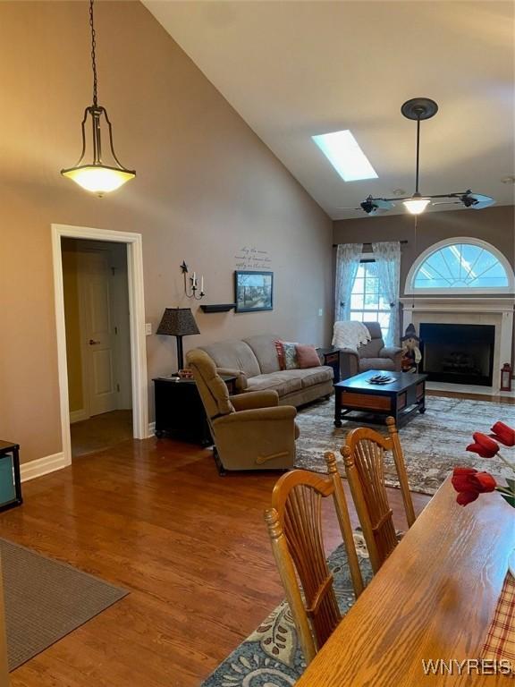 253 Glenvale Rd, Porter, NY 14174 - living room with high vaulted ceiling, a fireplace, a ceiling fan, a skylight, and wood finished floors