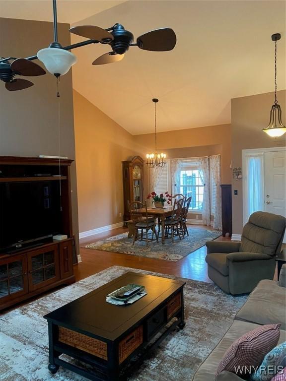 253 Glenvale Rd, Porter, NY 14174 - living room with baseboards, high vaulted ceiling, wood finished floors, and ceiling fan with notable chandelier