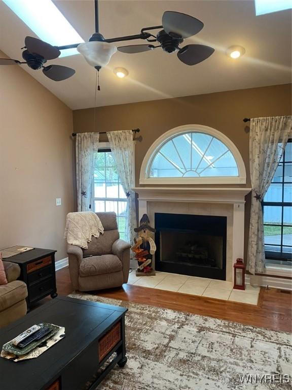 253 Glenvale Rd, Porter, NY 14174 - living room featuring a tiled fireplace, ceiling fan, wood finished floors, and baseboards
