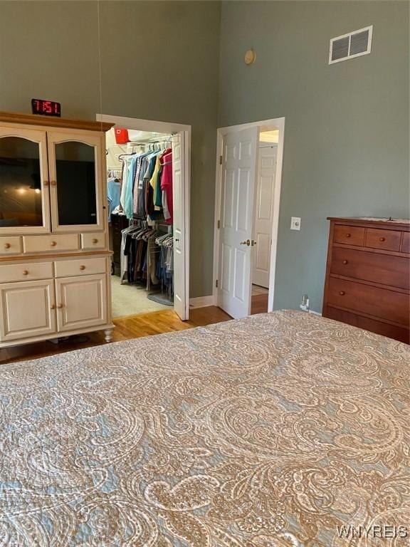 253 Glenvale Rd, Porter, NY 14174 - bedroom with light wood-type flooring, a closet, visible vents, a high ceiling, and a walk in closet