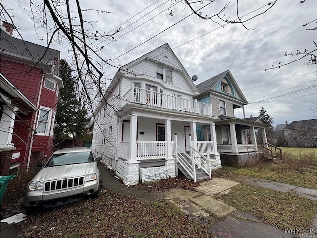 victorian house featuring covered porch and a balcony
