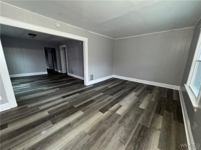 spare room with visible vents, baseboards, and wood finished floors