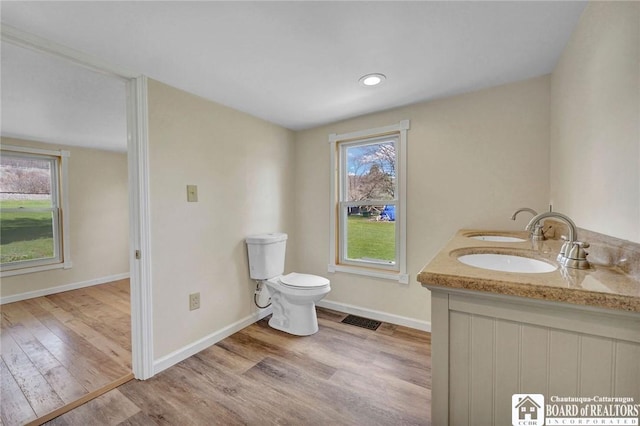 9056 Gross Rd, Cuba, NY 14727 - full bathroom with a sink, toilet, wood finished floors, visible vents, and baseboards