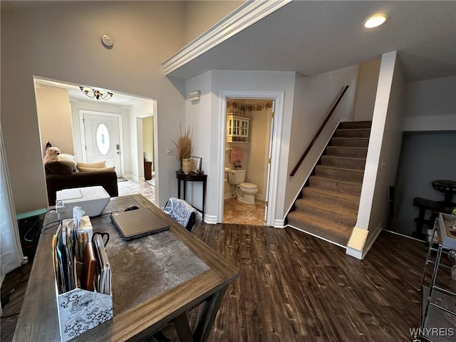 dining space featuring wood finished floors, baseboards, and stairs