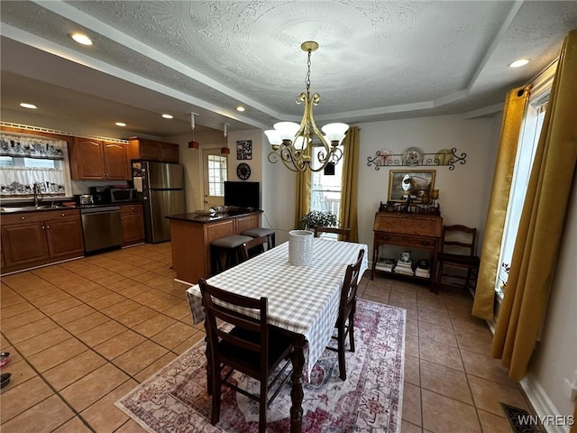 dining area featuring visible vents, a chandelier, a textured ceiling, a tray ceiling, and light tile patterned flooring