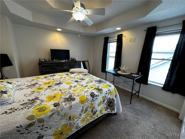 bedroom with a tray ceiling, carpet flooring, baseboards, and recessed lighting