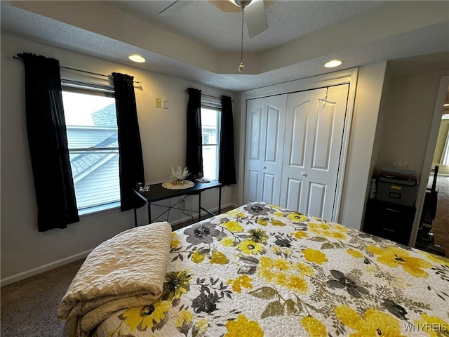 carpeted bedroom with a closet, recessed lighting, baseboards, and a textured ceiling
