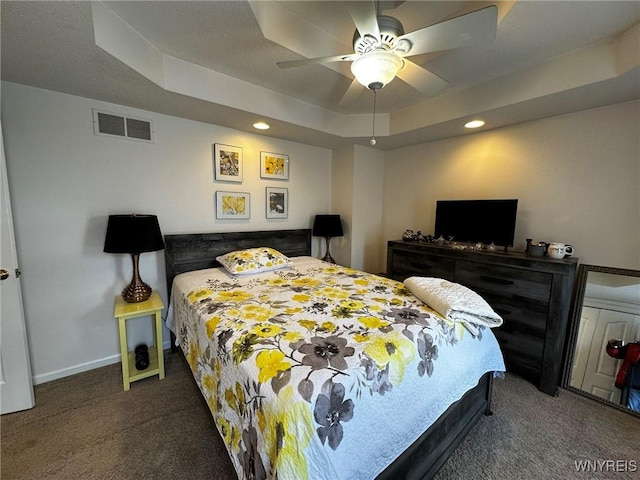carpeted bedroom with visible vents, baseboards, a raised ceiling, ceiling fan, and recessed lighting