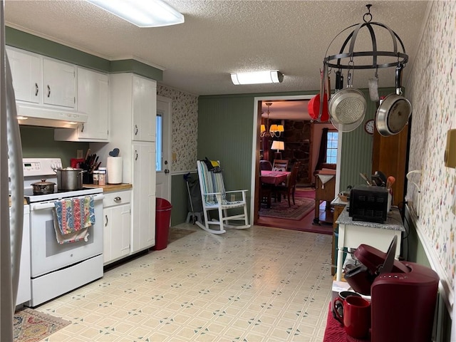 kitchen featuring white cabinets, under cabinet range hood, white electric range, and wallpapered walls