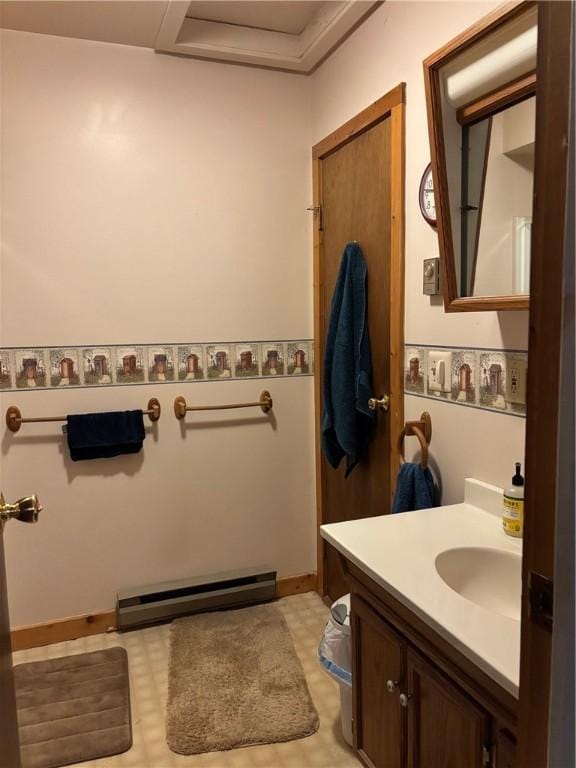 bathroom with tile patterned floors, a baseboard heating unit, baseboards, and vanity