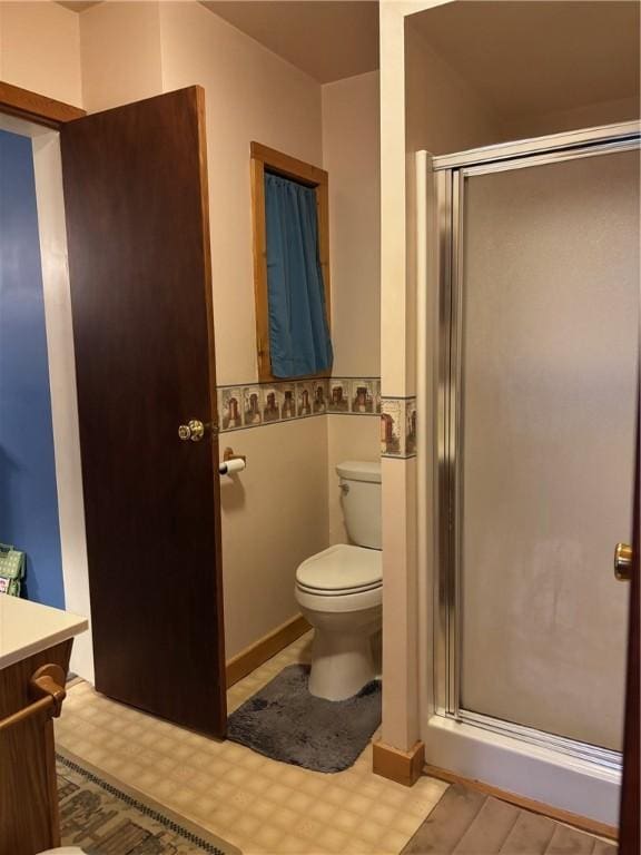 full bath featuring toilet, a shower stall, vanity, and wood finished floors