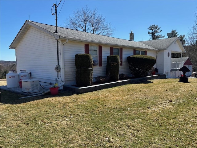 view of side of property featuring a yard and a chimney
