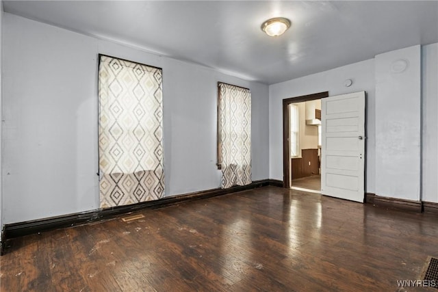 empty room featuring baseboards and hardwood / wood-style floors
