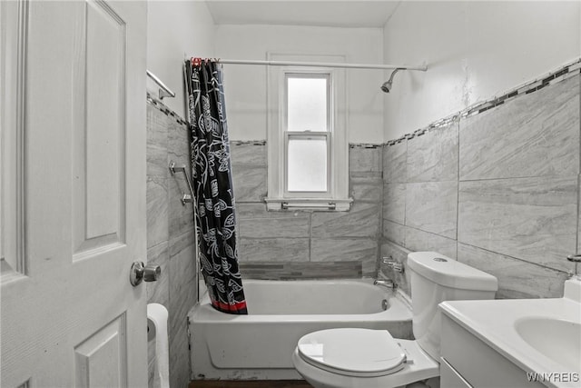 bathroom with toilet, tile walls, vanity, and shower / bath combination with curtain