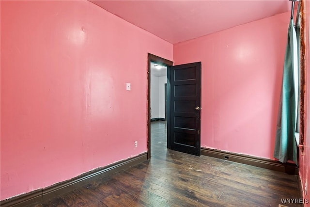 unfurnished room with baseboards and wood finished floors