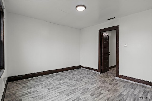 unfurnished room featuring light wood-type flooring and baseboards