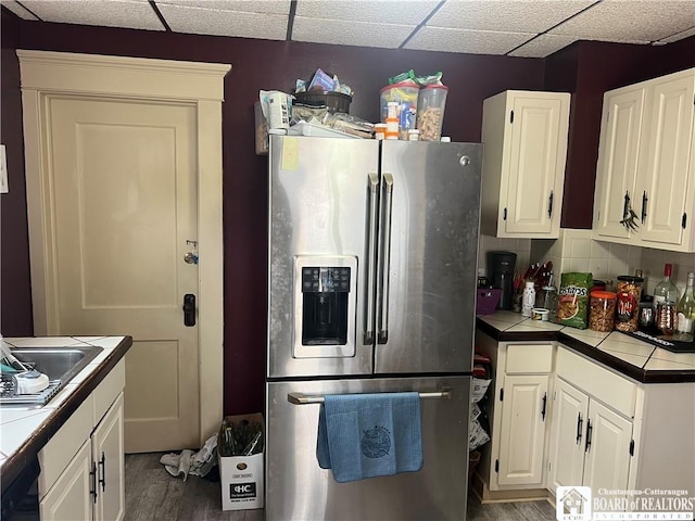 9 Columbia Ave, Ellicott, NY 14701 - kitchen featuring white cabinetry, wood finished floors, tile counters, and stainless steel fridge