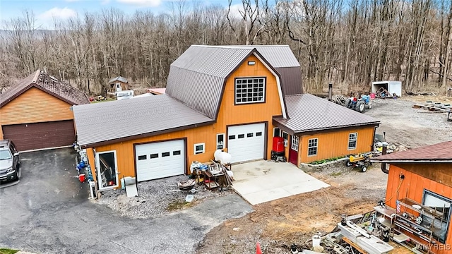 view of front of property with a garage, a gambrel roof, and metal roof