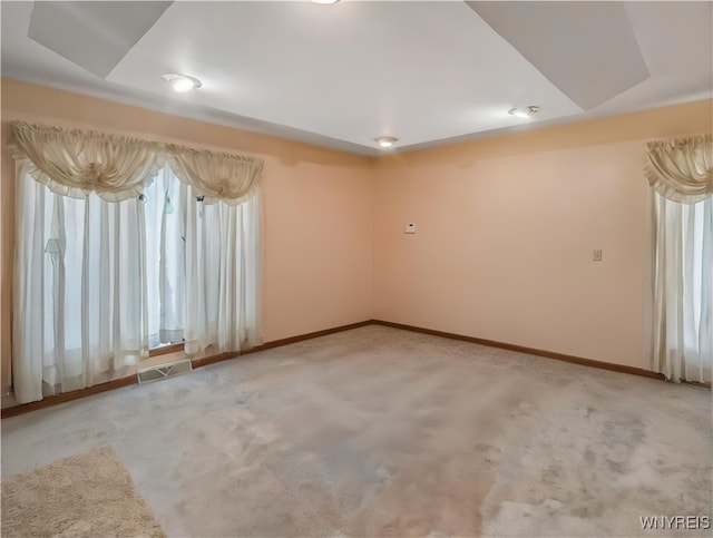 unfurnished room featuring visible vents, baseboards, and light carpet